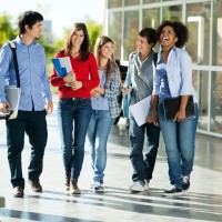 Full length of cheerful university students walking on campus