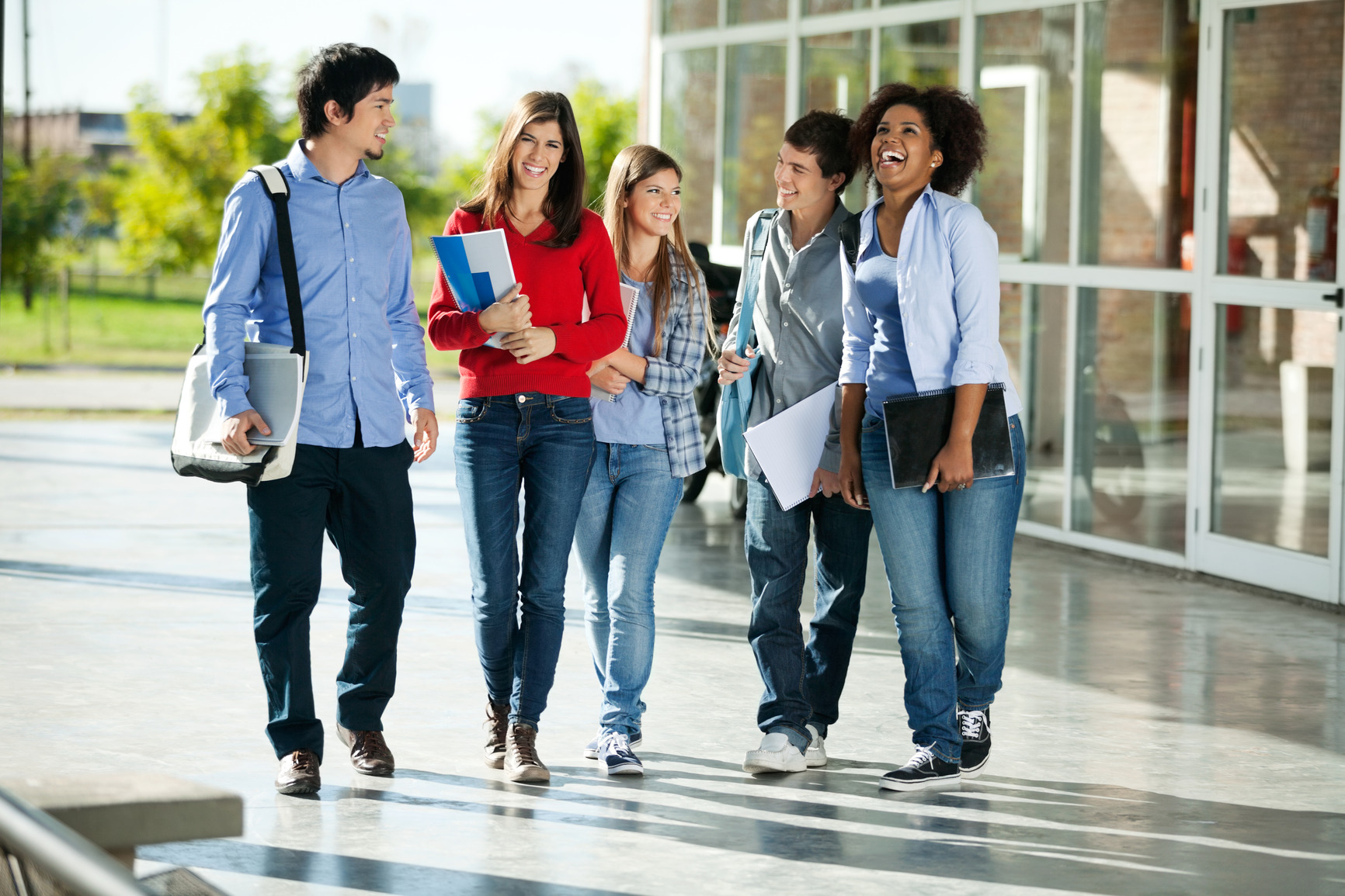 Full length of cheerful university students walking on campus